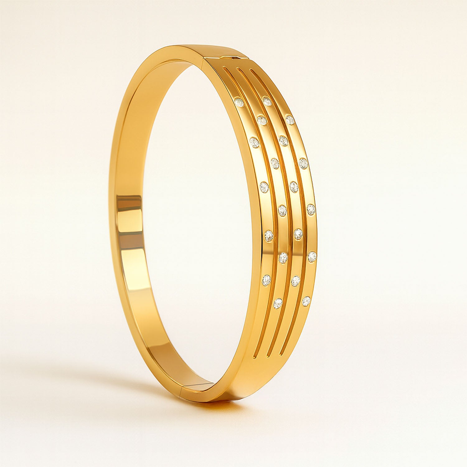 Gold bracelet with embedded diamonds on a beige background